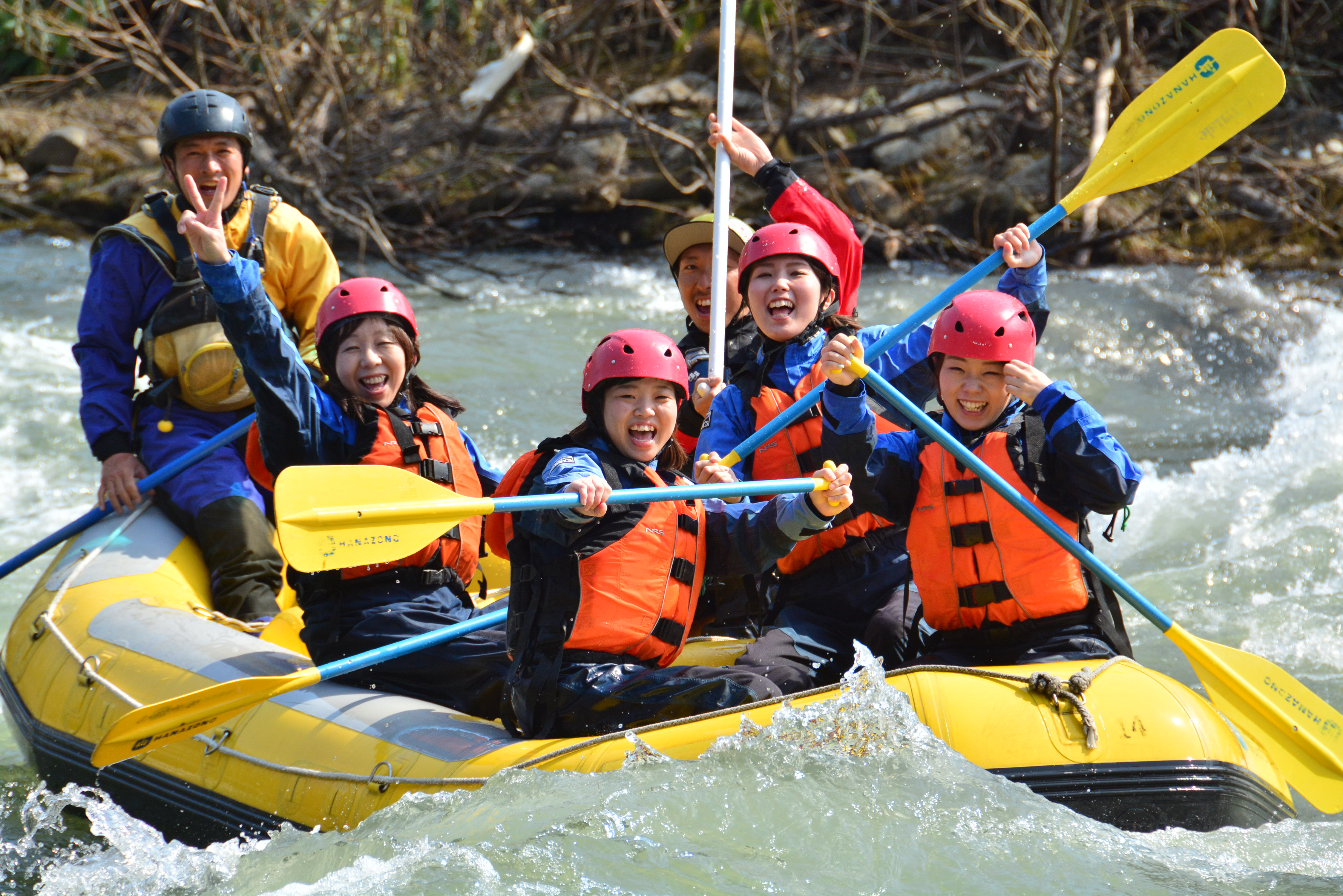 A group of people having fun rafting down the river in Hanazono, Niseko.